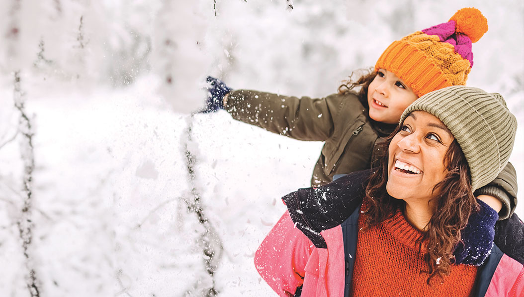 woman with daughter in the snow at winter